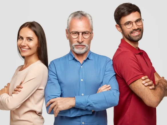 Imagem de três pessoas, um homem idoso com cabelo grisalho, um homem mais jovem com barba e uma mulher sorridente, todos se destacando em um fundo neutro. A imagem representa diversidade e confiança em um ambiente profissional.